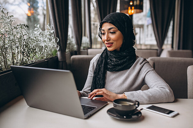 Woman sitting in front of her laptop in an online meeting.